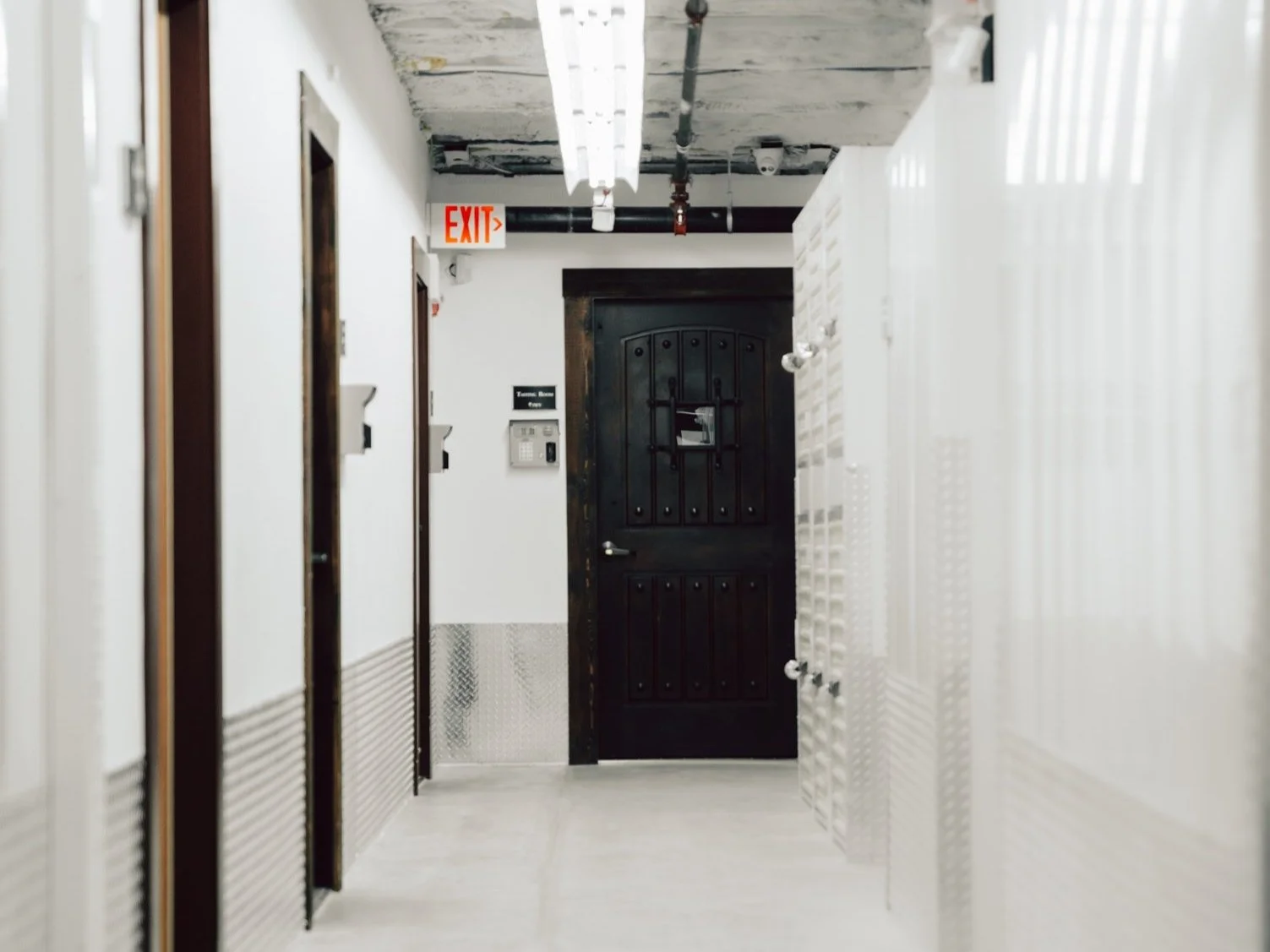 Hallway leading to a door with storage facilities on either side